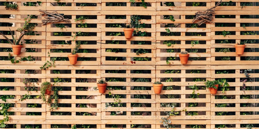 Pallets in Interior Design - a Wall of Wooden Pallets with Flower Pots.