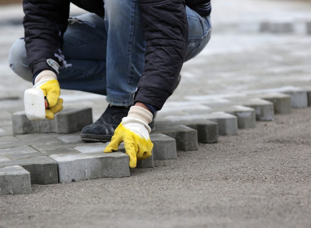 Person laying stone pavers